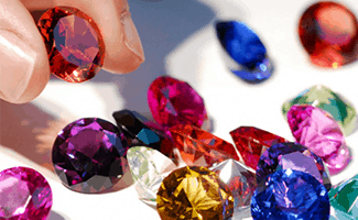 A vibrant display of various colored gemstones being graded according to international standards for the SGL Colored Gemstone Specialist course.